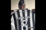 Lamar Jackson recebe camisa do Botafogo durante visita ao CT Lonier